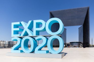 Dubai, BAE, 17.10.2021. Expo 2020, Mobilite Bölgesi girişinde mavi logo işareti. Arkasında Expo 2020 binaları var..
