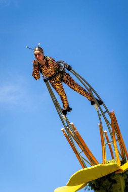 Dubai, BAE, 09.12.2021. Arı kostümü giymiş bir kadın, 2020 Dubai Daily Parade Fuarı 'nda büyük sarı çiçeğe takılı akrobasi gösterisi yapıyor..