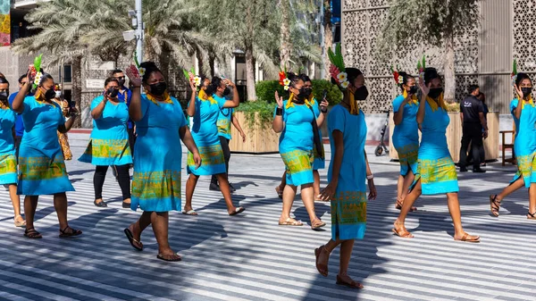 Dubai, BAE, 09.12.2021. 2020 Dubai Fuarı 'nda Palau Ulusal Günü geçit töreni, Palau kadınları geleneksel mavi elbiseler ve saçlarında çiçeklerle yürüyor.