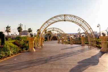 Dubai, BAE, 10.01.21. Dubai 'deki Global Village eğlence parkı, yanan kavisli ahşap gezinti güvertesi, fenerler..