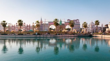 Dubai, BAE, 10.01.21. Dubai 'deki Küresel Köy eğlence parkının manzara manzarası Pakistan ve Türkiye ulusal pavyonları günbatımı sırasında turkuaz su göletine ve tarihi minyatürlere yansıyor.