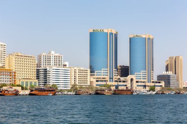 Dubai, BAE, 27.09.2021. Dubai Kanalı 'na demirlemiş Rolex İkiz Kuleleri ve geleneksel ahşap tekneleri olan Deira Skyline..