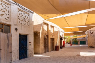 Al Fahidi Tarihi Taştan Sokak. Üzerinde süs ve güneş gözlüğü olan geleneksel Arap tarzı binalar. Deira, Dubai, Birleşik Arap Emirlikleri..