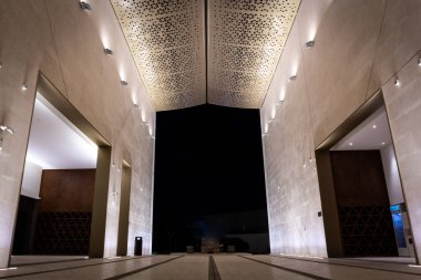 Illuminated courtyard of Mosque of Light in Dubai, facade and roof with triangular geometric patterns.