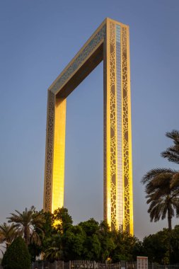 Dubai, BAE, 24.09.21. Altın saat boyunca Dubai Çerçevesi, etrafında palmiye ağaçları, Dubai 'nin mimari simgesi, dünyanın en büyük çerçevesi.