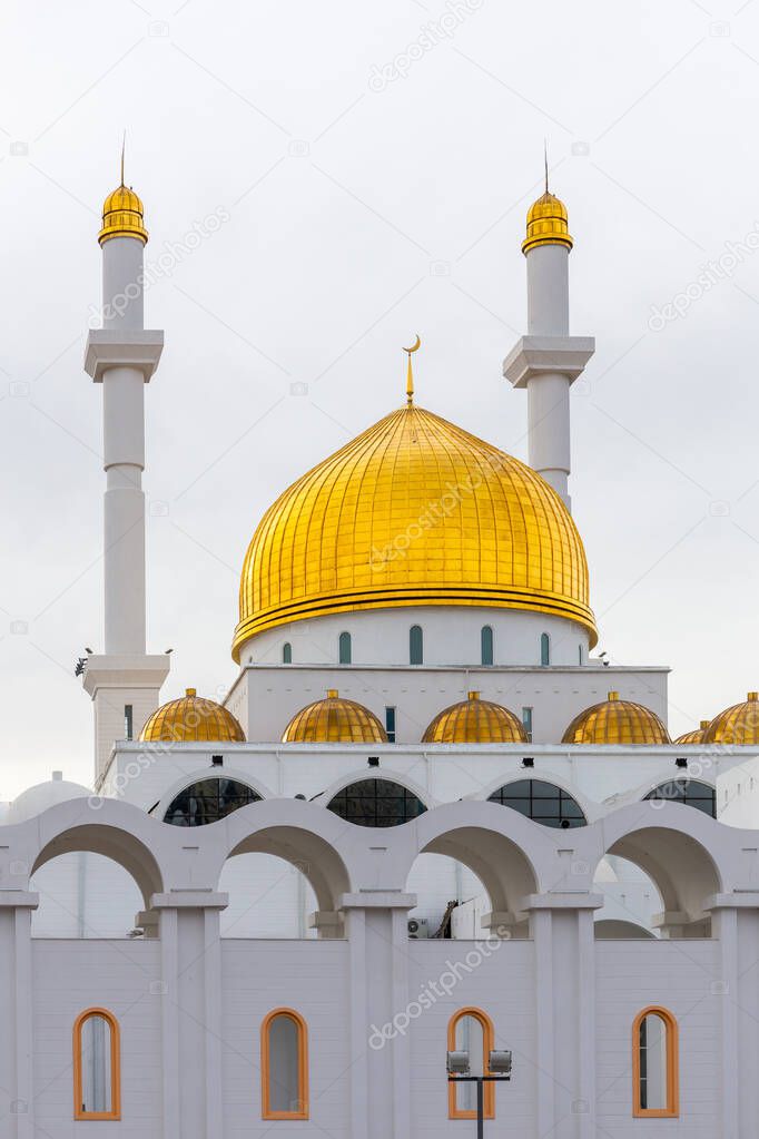 Nur Astana Mosque (Nur Astana Meshiti) in Nur Sultan, Kazakhstan, with white facade and golden dome and ornaments.