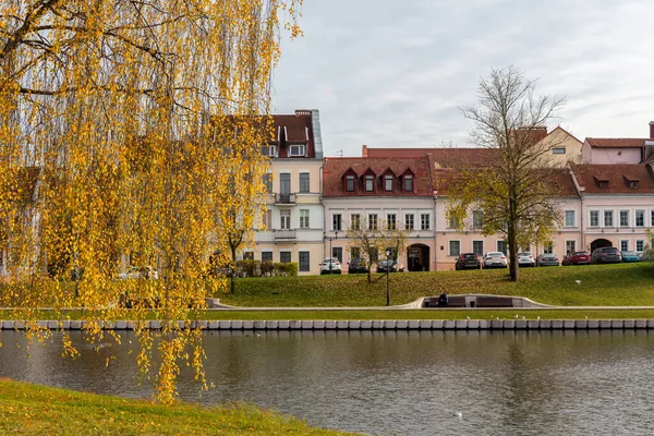 Minsk, Belarus 'taki Trinity Banliyösü, Upper City Minsk' in en eski bölgesinde, sonbaharda Svislach Nehri kıyısında turuncu sonbahar yapraklarıyla eski renkli geleneksel binalar..