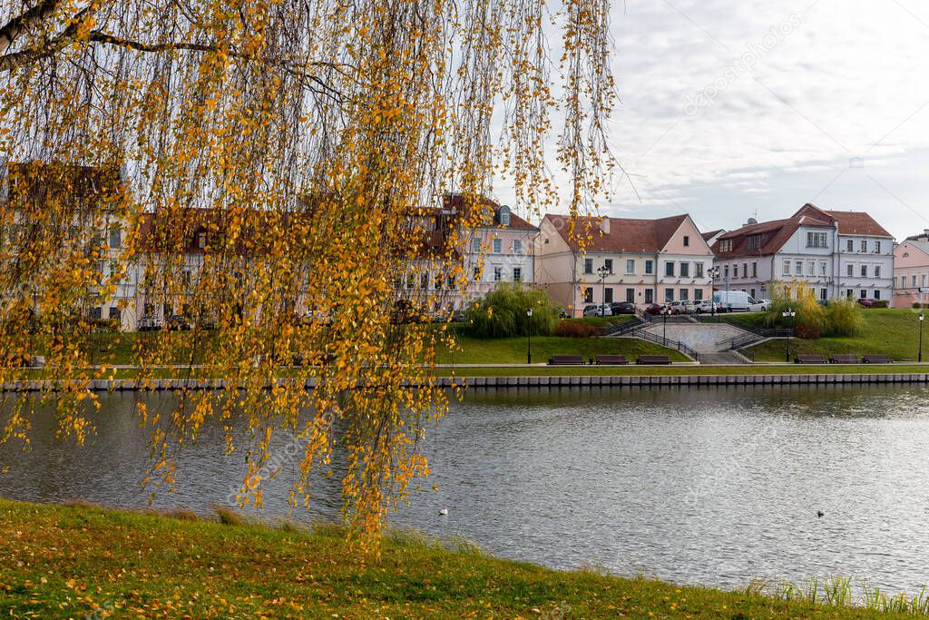 The Trinity Suburb in Minsk, Belarus, old colorful traditional buildings in the oldest district in Upper City Minsk by Svislach River in autumn with orange autumn leaves.