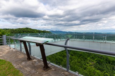 Gürcistan 'da Sataplia Doğa Koruma Platformu' nda panoramik bilgi haritasıyla doğal manzaraya bakan saydam zemin.