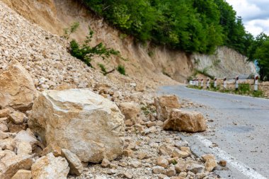 Limestone rockfall and landslide fallen and blocking tarmac road leading to Khvamli Mountain peak in Georgia. clipart