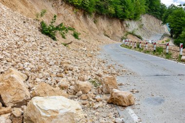Limestone rockfall and landslide fallen and blocking tarmac road leading to Khvamli Mountain peak in Georgia.