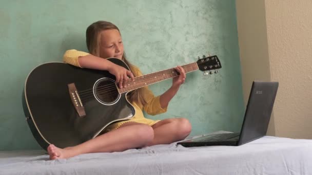 Een klein meisje leert gitaar spelen — Stockvideo