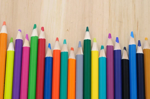 木製の背景に色鉛筆を描くグループ — ストック写真
