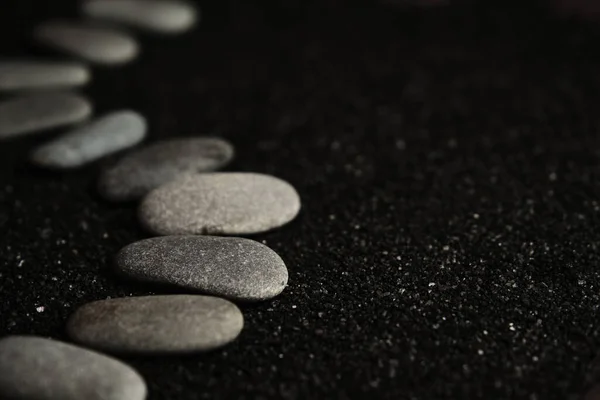 Pequeños guijarros de mar se colocan sobre un fondo negro — Foto de Stock