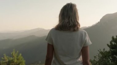 Bir kadın dağda duruyor.