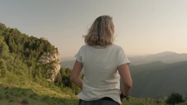 Женщина смотрит на горный пейзаж — стоковое видео