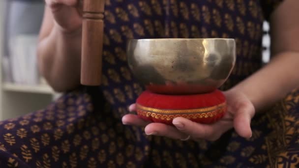 A girl holds a Tibetan bowl in her hands — Vídeo de Stock