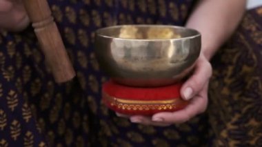 Bir kız elinde bir Tibet kasesi tutuyor.