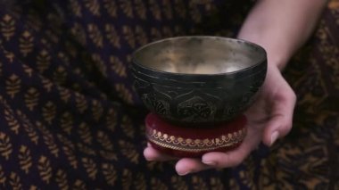 Bir kız elinde bir Tibet kasesi tutuyor.