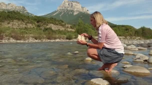 Una joven mujer dedica runas en un río de montaña — Vídeo de stock