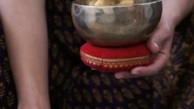 Bir kız elinde bir Tibet kasesi tutuyor.