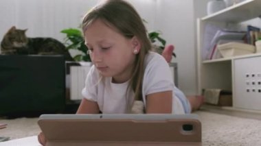 Tabletli bir kız ödevini yapıyor.