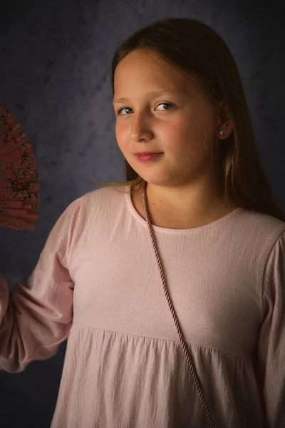 Studio Portrét Dívky Růžových Šatech Ventilátorem Ruce Tmavém Pozadí — Stock fotografie