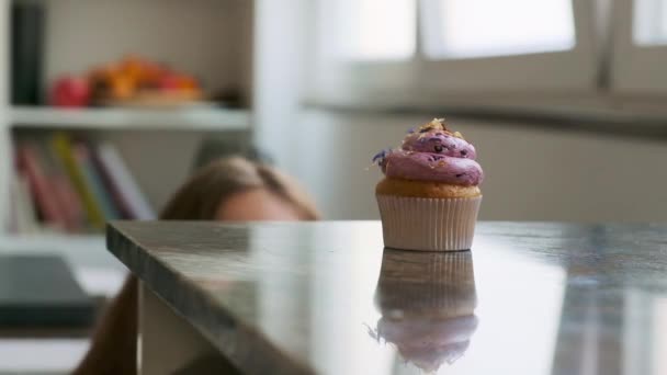Das Mädchen Nimmt Einen Leckeren Cupcake Mit Sahne Vom Tisch — Stockvideo