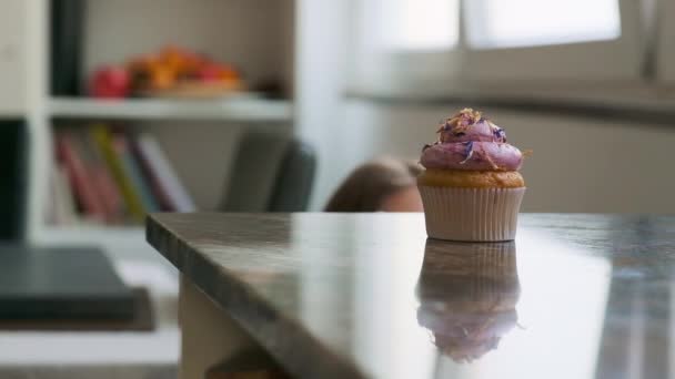 Das Mädchen Nimmt Einen Leckeren Cupcake Mit Sahne Vom Tisch — Stockvideo