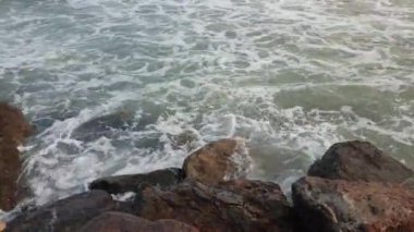 Deniz dalgaları kayalara çarpıyor.