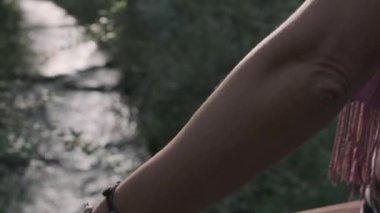 Kız köprüde durur ve nehre bakar.