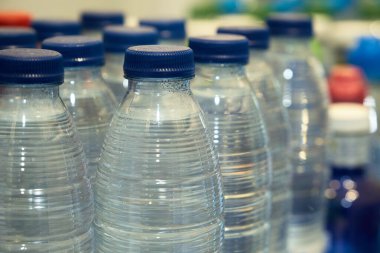 Dükkandaki rafta küçük bir şişe içme suyu var.