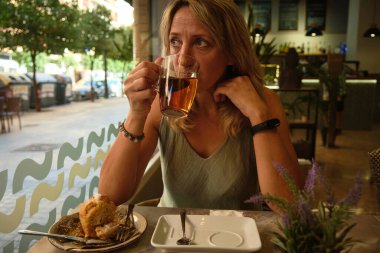 Bir kız zarif bir kafede keklerle bir saat içer.