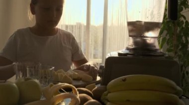 a girl prepares a fruit and milk cocktail