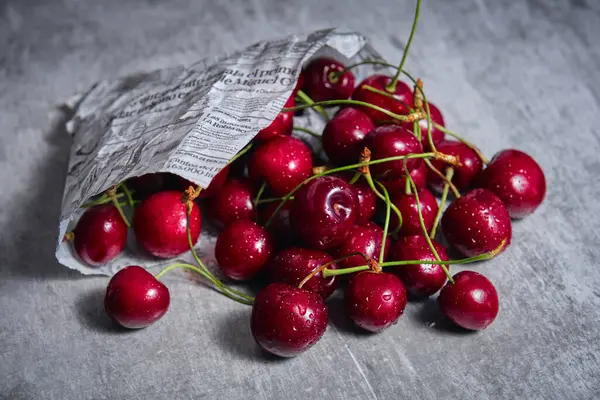 Ripe Cherries Newspaper Bag Table — стоковое фото