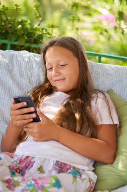 blonde girl sitting on the terrace with a phone
