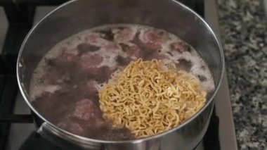 Chinese noodles are put in boiling water