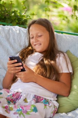 blonde girl sitting on the terrace with a phone