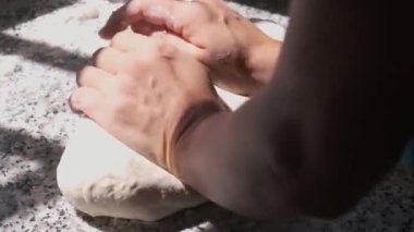 Ekmek için hamur yoğuran kadınların elleri.