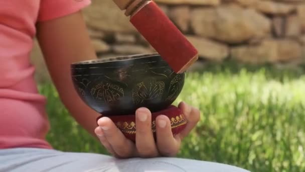 Девушка Сидит Траве Саду Тибетской Чашей Руках — стоковое видео