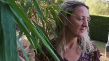 Yeşilliğin arka planına karşı bahçede bir kızın ağır çekimde portresi.