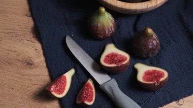 Yanlarındaki ahşap kasede olgun incirler bir bütün ve parçalara bölünmüş.