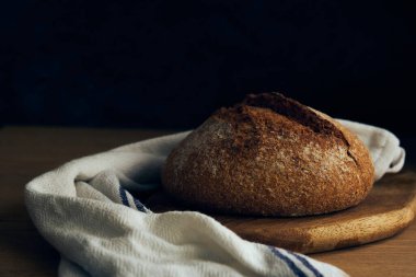 Bir somun çavdar ekmeği sade ahşap tahta üzerinde