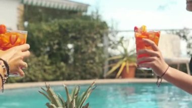 Yüzme havuzunda elinde kokteyllerle bikinili iki güzel kız.