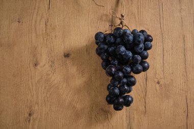 Tahta arka planda bir demet üzüm meyvesi.