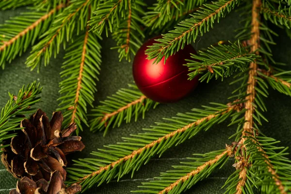 Jedlové větve s jehlami a kužely s vánoční hračky detailní up. — Stock fotografie