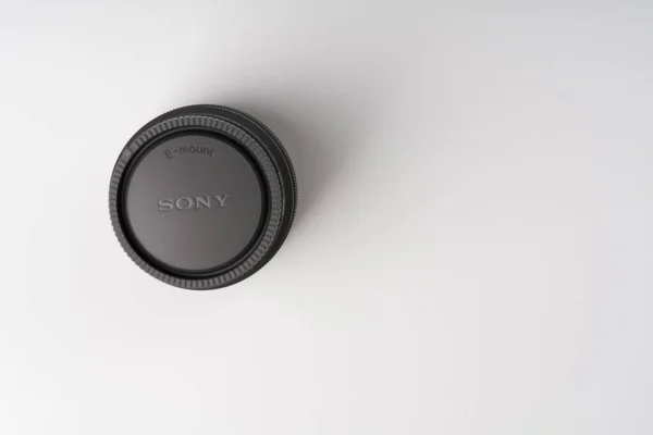 MOSCOW, RUSSIA-2 de outubro de 2021: A lente de 50 mm 1.8 full-frame Sony baseia-se nos cálculos realizados sobre um fundo branco. A inscrição da marca sony é visível na tampa protetora de fechamento — Fotografia de Stock