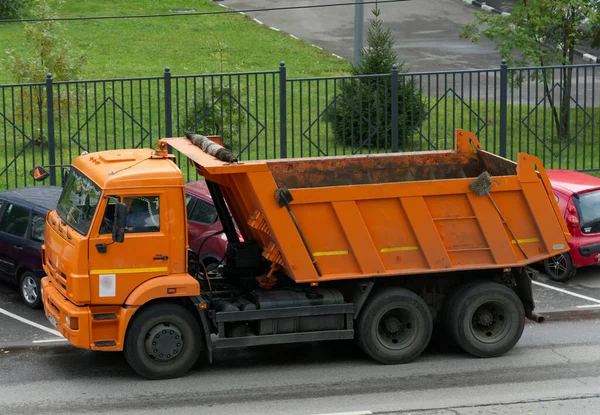 MOSCÚ, RUSIA-15 de octubre de 2021: Un camión naranja de una empresa de construcción está parado en la carretera —  Fotos de Stock