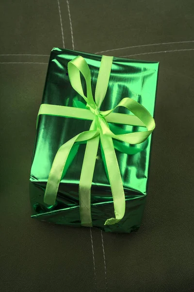 Une belle boîte cadeau de couleur verte attachée avec un ruban. — Photo