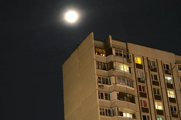 Księżyc na tle ciemnego nieba i wieżowiec mieszkalny. — Zdjęcie stockowe